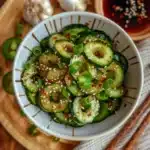 spicy cucumber salad recipe in white bowl with chili oil
